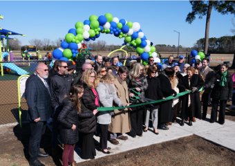 Group of peopple cutting Ribbon the playground